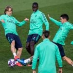 El centrocampista croata Luka Modric (i), el defensa francés Froilan Mendy (c), y el centrocampista colombiano James Rodriguez (2-d), este martes, durante el entrenamiento del conjunto blanco en la Ciudad Deportiva del Real Madrid en Valdebebas (Madrid), previo al partido de ida de octavos de final de la Liga de Campeones que disputa mañana frente al Manchester City en el Estadio Santiago Bernabéu. EFE/Rodrigo Jiménez