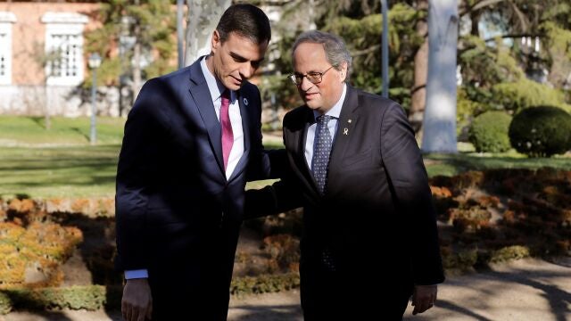 El presidente del Gobierno, Pedro Sánchez (i) conversa con el presidente de la Generalitat, Quim Torra, a su llegada a la primera reunión de la mesa de diálogo para solucionar el conflicto político en Cataluña, este miércoles en Moncloa.