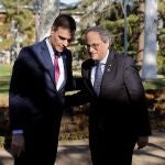 El presidente del Gobierno, Pedro Sánchez (i) conversa con el presidente de la Generalitat, Quim Torra, a su llegada a la primera reunión de la mesa de diálogo para solucionar el conflicto político en Cataluña, este miércoles en Moncloa.