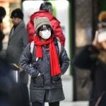 Una mujer se protege del coronavirus con una mascarilla