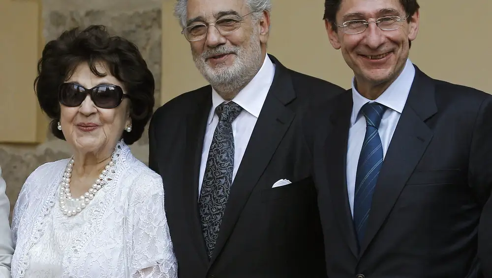 GRA370. ALCALA DE HENARES (MADRID), 18/07/2013.- El tenor Plácido Domingo (c) junto a su esposa Marta Ornelas, y el presidente del Consejo Asesor del Instituto Franklin y de Bankia, José Ignacio Goirigolzarri (d), a su llegada al acto de entrega del segundo premio "Camino Real" que ha recibido el cardiólogo Valentín Fuster, hoy en el Paraninfo de la Universidad de Alcalá de Henares. El tenor fue galardonado el pasado año con el primer premio Camino Real. EFE/Ballesteros