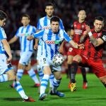 Los jugadores de la Real Sociedad Aritz Elustondo (i) e Igor Zubeldia (c), luchan con Antonio Sánchez (d), del Mirandés. EFE/Santi Otero