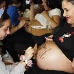 Una de las embarazadas se deja pintar el vientre por una niña en el Hospital Vinalopó, de Ribera Salud