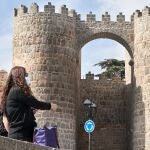 Una turista con mascarilla junto a la muralla de Ávila. EFE/ Raúl Sanchidrián
