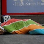 Una persona sin hogar duerme junto a su paquete de papel higiénico en los alrededores de la Puerta del Sol de Madrid . EFE/ Chema Moya