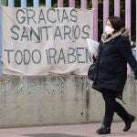 Una mujer embarazada pasa por delante de una pancarta colocada en la valla un hospital. EFE/NACHO GALLEGO