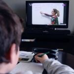 Un niño sigue desde el televisor de su casa