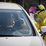 Un sanitario realizando hoy un test móvil de coronavirus a una conductora en el puesto instalado junto un hospital
