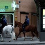 Dos policías a caballo este martes en una calle de Madrid durante el estado de alarma decretado a causa de la pandemia de coronavirus. EFE/ Mariscal