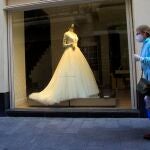 Una transeúnte pasa ante una tienda de trajes de novias en Sevilla 