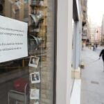 Cartel en la ventana de un establecimiento cerrado en una calle prácticamente vacía