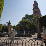 MEX9117. MORELIA (MÉXICO),06/04/2020.- Personal Sanitario limpia hoy lunes una plaza pública en Morelia, Michoacan (México). México acumula 2.143 casos de COVID-19 y 94 fallecidos, un alza de 15 personas muertas más en las últimas 24 horas, según el informe técnico oficial de la epidemia presentado ayer domingo por las autoridades de salud. EFE/Ivan Villanueva