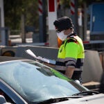 Un agente de los Mossos d'Esquadra protegido con una mascarilla en un control en el peaje de La Roca del Vallès pide a un conductor el justificante que le permite su salida de casa durante un Jueves Santo atípico en el que prosigue el estado de alarma decretado por el Gobierno para la lucha contra el coronavirus, en La Roca del Vallès/Barcelona/Catalunya (España) a 9 de abril de 2020.09 ABRIL 2020 COVID-19;PANDEMIA;CORONAVIRUS;COCHES;POLICÍA;TRÁFICO;ENFERMEDAD;CONFINAMIENTODavid Zorrakino / Europa Press09/04/2020