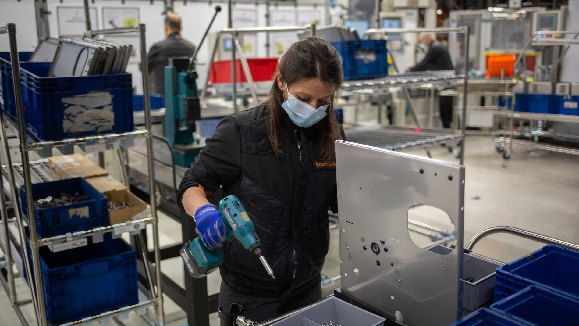 Una operaria trabaja en una cadena de producción y montaje
