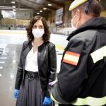 Isabel Díaz Ayuso habla con un militar de la UME durante la clausura de la morgue del Palacio de Hielo de Majadahonda