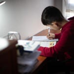Un niño realiza sus deberes en su habitación durante el confinamiento por el estado de alarma
