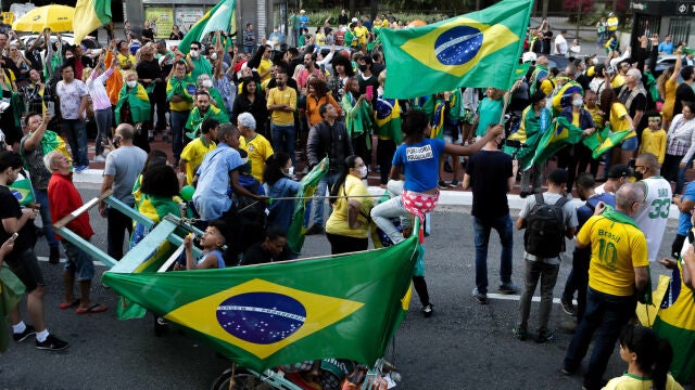 19 April 2020, Brazil, Sao Paulo: Supporters of Brazilian President Jair Bolsonaro hold flags during a protest demand for the reopening of trade and against the National Congress and the government of Sao Paulo, which extended the quarantine in the state to delay the spread of the new coronavirus. Photo: Dario Oliveira/ZUMA Wire/dpa19/04/2020 ONLY FOR USE IN SPAIN