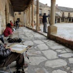 Un turista dibuja en la plaza de Pedraza (Segovia)