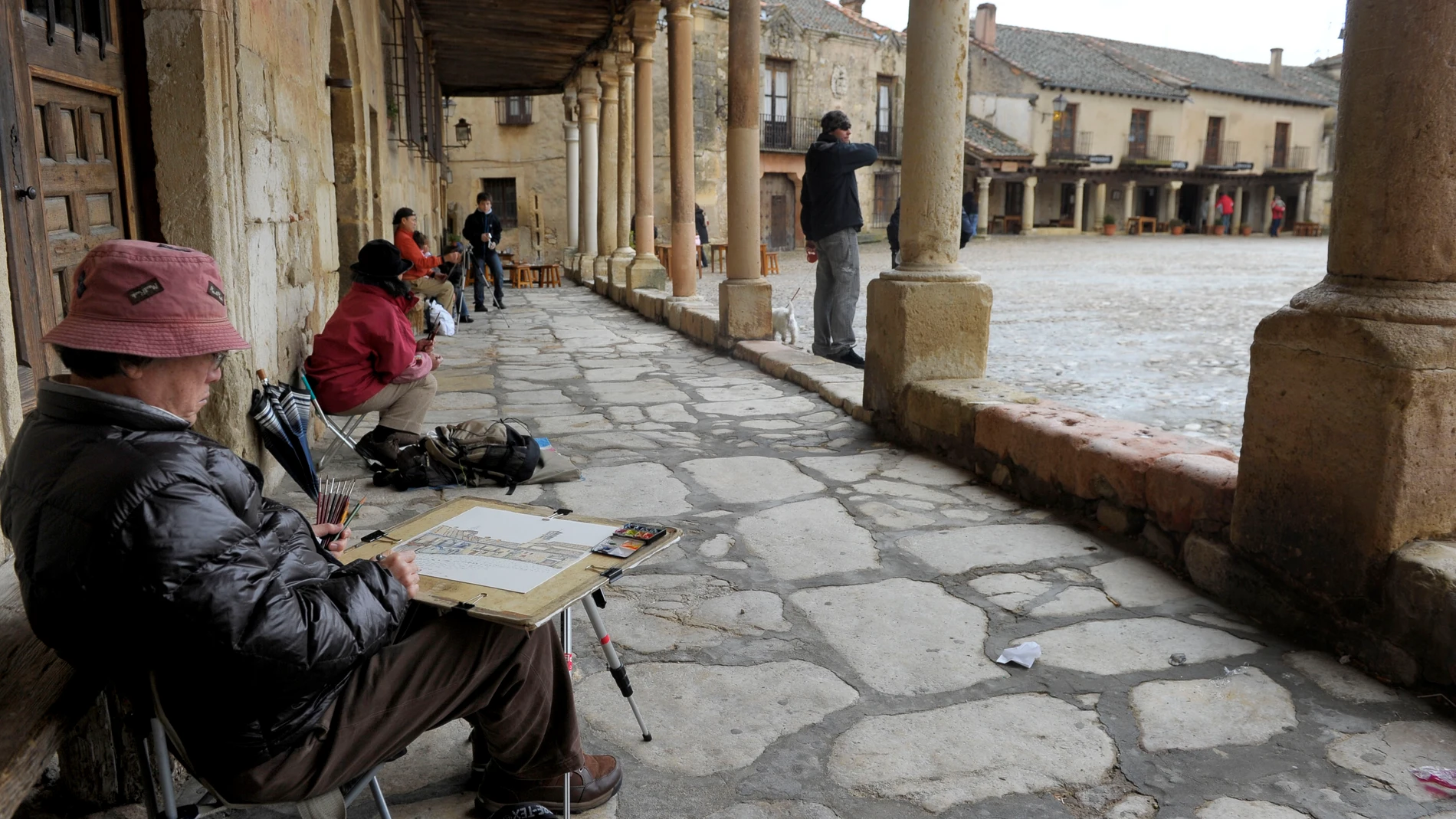 Un turista dibuja en la plaza de Pedraza (Segovia)