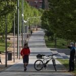 Un policía pide a unos corredores que abandonen el interior de Madrid Río, uno de los mayores parques de Madrid, cerrado por orden municipal
