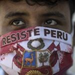 John Sanches wears a face mask with the Spanish message "Resist Peru" as he waits in line to be tested for COVID-19 at Almenara Hospital in Lima, Peru, Friday, April 24, 2020. (AP Photo/Rodrigo Abd)