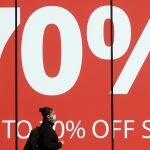 Una mujer pasa junto a una tienda cerrada en Oxford Street, Londres