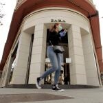 GRAF2410. A CORUÑA, 07/05/2020.- Una mujer con mascarilla caminaba este jueves frente a la emblemática tienda de Zara en la calle Juan Flórez de A Coruña, la primera abierta por el fundador de Inditex, Amancio Ortega, durante la reapertura de las tiendas más pequeñas de la multinacional, las menores de 400 metros cuadrados, con cita previa y con la admisión como máximo de cuatro clientes a la vez en el local. EFE/Cabalar