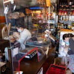 Una mampara instalada en una tienda de comestibles separa a los clientes de los vendedores
