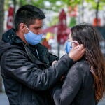 Una pareja con mascarillas en la principal calle comercial de Amberes, Bélgica