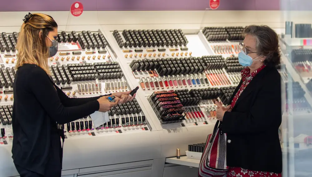 Una empleada de una tienda de cosmética atiende a una clienta durante el segundo día de la fase 1 del plan de desescalada que ha elaborado el Gobierno de España. En Sevilla, (Andalucía, España), a 12 de mayo de 2020.12 MAYO 2020María José López / Europa Press12/05/2020