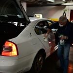 José Manuel, protegido con mascarilla y guantes, procede a la limpieza del taxi en un garaje de la Colonia de los Taxistas en Vallecas, Madrid