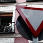 Un vecino del barrio de Lavapiés lee en un balcón