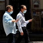 Dos personas caminan con mascarillas