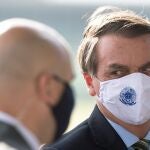 AME924. BRASILIA (BRASIL), 19/05/2020.- El presidente de Brasil, Jair Bolsonaro (d), sale del Palacio do Alvorada este martes, en Brasilia (Brasil). Brasil se convirtió este lunes en el tercer país más afectado por el COVID-19, tras superar a Reino Unido en el número de casos, y la tendencia es que los números de contagiados y muertos sigan creciendo de forma exponencial hasta julio, para cuando se espera el pico de la curva de incidencia. EFE/ Joédson Alves