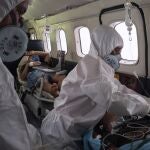 Doctor Daniel Siqueira, left, and nurse Janete Vieira monitor COVID-19 patients AbraÃ£o Lasmar, left, and Sildomar Castelo Branco onboard an aircraft as they are transferred from Santo AntÃ´nio do IÃ§a to a hospital in Manaus, in Brazil's Amazon state, Tuesday, May 19, 2020. (AP Photo/Felipe Dana)