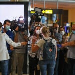 Una pasajera del primer vuelo internacional desde que se decretó el confinamiento por la crisis sanitaria, responde este jueves a los medios de comunicación que esperan a la salida del aeropuerto de Manises (Valencia)