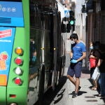 Varias personas se suben y bajan de un autobús del Consorcio regional