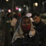 Homeless and unemployed wearing masks against the spread of the new coronavirus lineup to receive a free meal in Mexico City, Wednesday, May 20, 2020. The volunteers running the soup kitchen say they have had to expand their service from a single day to two days per week as the number of people in need grows. (AP Photo/Fernando Llano)