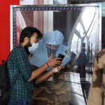 Un empleado de seguridad del aeropuerto Indira Gandhi de Nueva Delhi comprueba la identidad de un pasajero