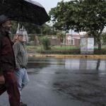 Linford asiste con un paraguas al activista de 76 años Marco Castillo, durante un día lluvioso en San José, Costa Rica. Castillo hace más de tres décadas inició un camino hacia la igualdad, lleno de rechazos, obstáculos, pero también de satisfacciones y logros, el último de ellos el matrimonio igualitario en Costa Rica, que entrará en vigor hoy por orden de la Sala Constitucional
