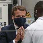 El presidente francés, Emmanuel Macron, con mascarilla, charla con un trabajador de la planta de Valeo en Etaples