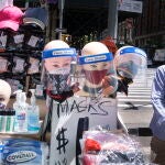 Un hombre camina en Nueva York junto a un puesto que vende mascarillas y geles desinfectantes