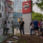 Trabajadores de Nissan cuelgan carteles como signo de protesta en el corte que han realizado en la Gran Vía de L’Hospital (Barcelona), cerca del concesionario de Nissan Motor Llansà.