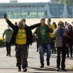 BRA100. BRASÍLIA (BRASIL), 01/06/2020.- Partidarios del presidente de Brasil, Jair Bolsonaro (fuera de cuadro), salen este lunes, del Palacio do Alvorada, tras haber sido recibidos por el presidente, en Brasilia (Brasil). EFE/ Joédson Alves
