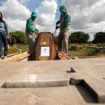 Empleados preparan a víctimas de COVID-19 para ser enterrados en el cementerio de Campo da Esperança, en Brasilia