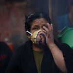 GU3006. ANTIGUA GUATEMALA (GUATEMALA), 03/06/2020.- Foto del 30 de abril de 2020 de una mujer que utiliza una mascarilla con la Virgen de Guadalupe impresa, mientras pide ayuda para su familia por el confinamiento que les imposibilita salir a trabajar. Guatemala puso en vigor este miércoles un acuerdo ministerial que organiza el desconfinamiento del país en cuatro fases y que funcionará como su "estrategia nacional" ante el COVID-19. EFE/Esteban Biba