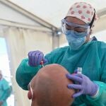 Una sanitaria realiza un test PCR a un vecino de Torrejón de Ardoz, este viernes. El Ayuntamiento de Torrejón mantiene una de las carpas habilitadas para realizar los test de seroprevalencia, para hacer pruebas PCR a los vecinos que dieron positivo en los anteriores. EFE/ Fernando Villar