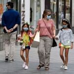 Imagen de archivo de varias personas, equipados con mascarillas, paseando por una calle de Sevilla