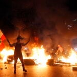 Un manifestante anitgubernamental porta una bandera libanesa durante las violentas protestas en Beirut