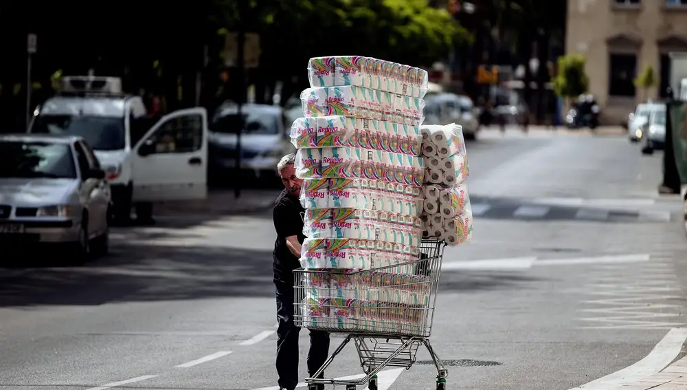 Fotografía del 12 de marzo del año 2020. Un hombre transporta numerosos rollos de papel higiénico. Un producto especialmente solicitado en aquel momento, debido a la pandemia del Coronavirus | Fuente: EFE/Jorge Zapata